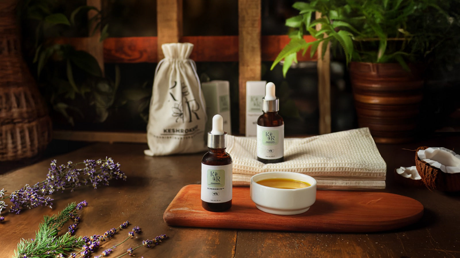 Keshrokkhi Hriddhi Superserum and Shondhi repair serum displayed on a rustic wooden table with natural oils and pouch- organic hair care for women in Dhaka, Bangladesh.