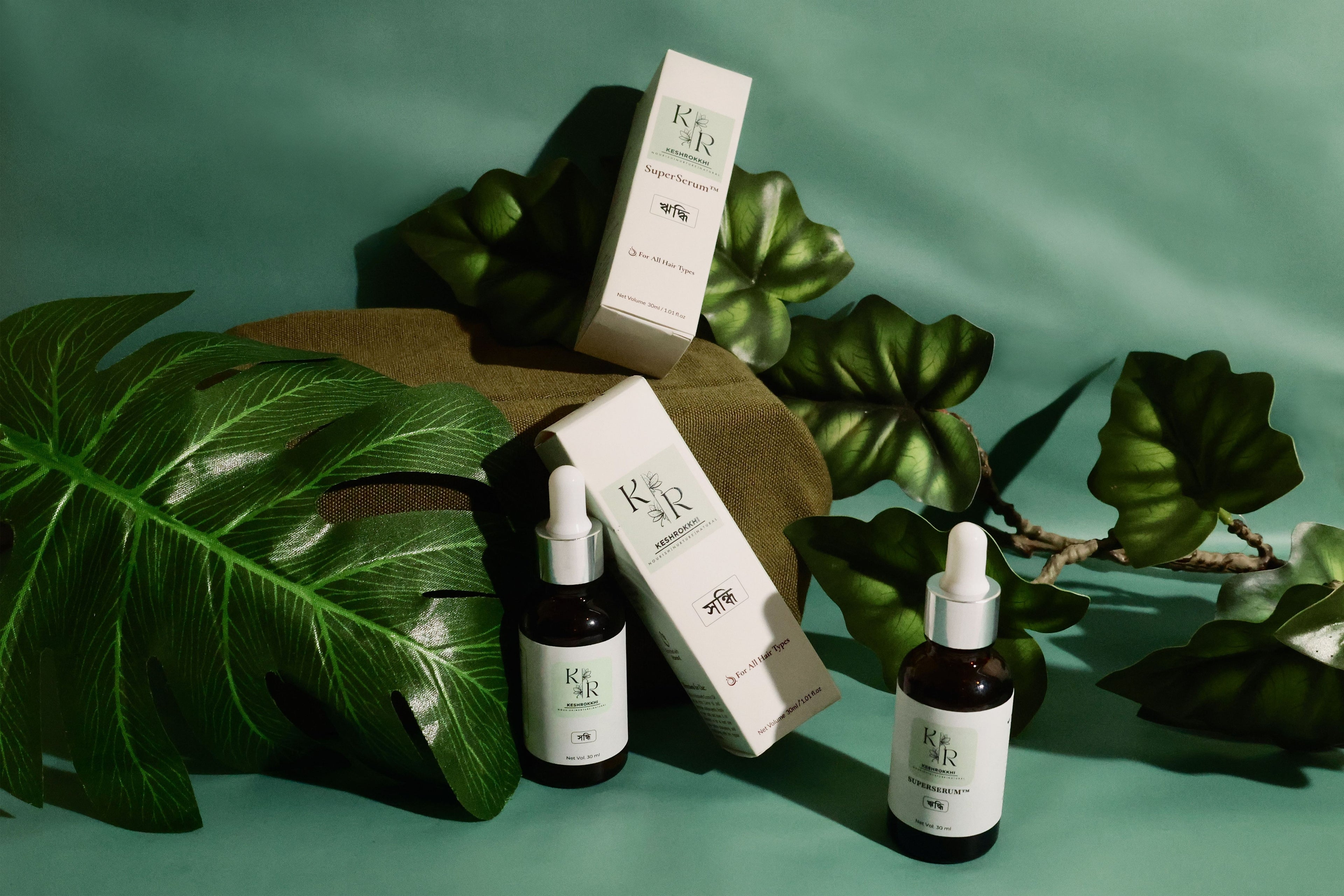 Keshrokkhi Hair care products placed on a leaf, known to be Bangladesh's best Hair Serum with Anti Hair Fall and Anti Hair Frizz benefits. 100% Organic