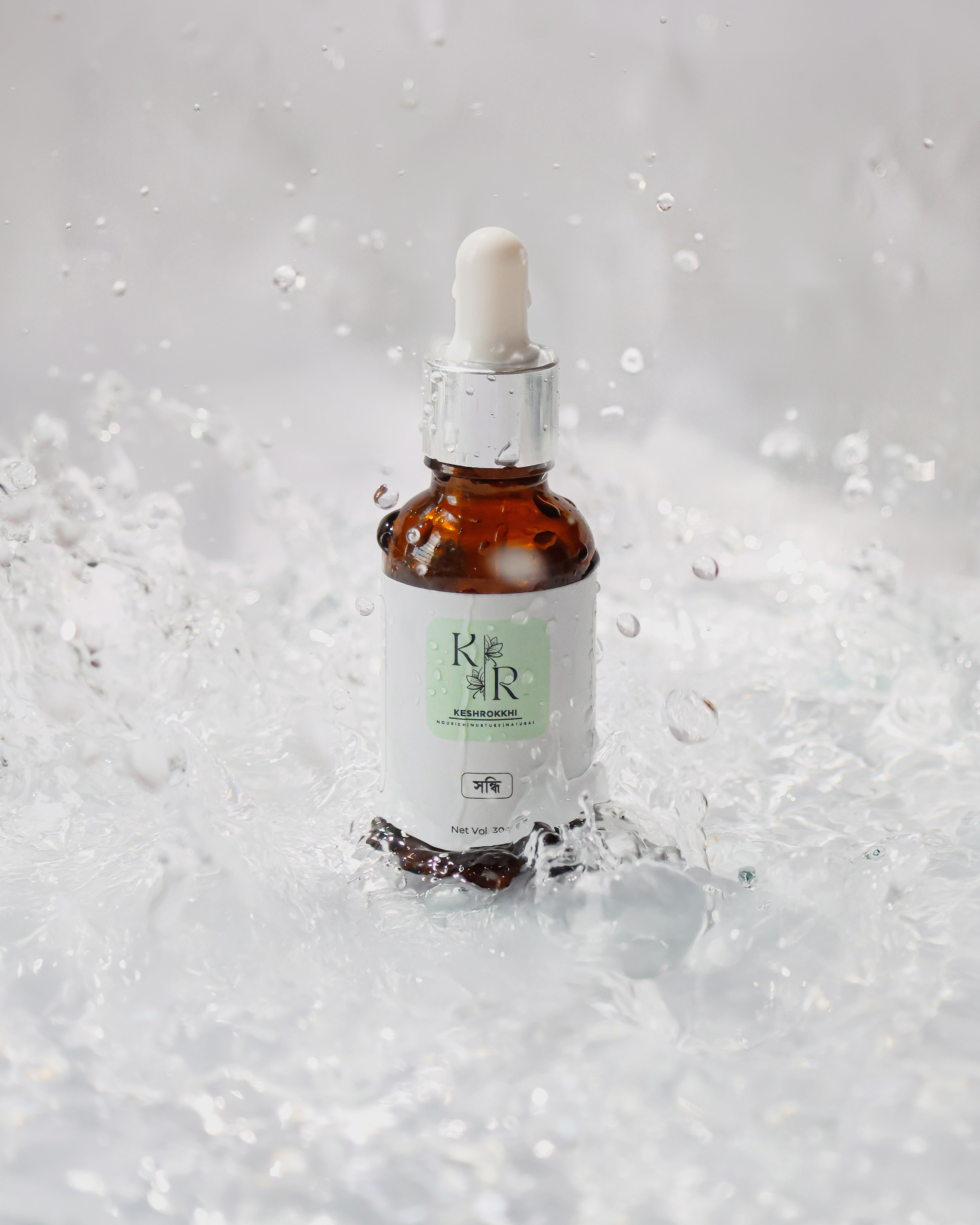 Shondhi Hair oil by Keshrokkhi captured mid-water splash for hydration and shine effect. 